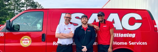 Three Isaac technicians in front of a service van