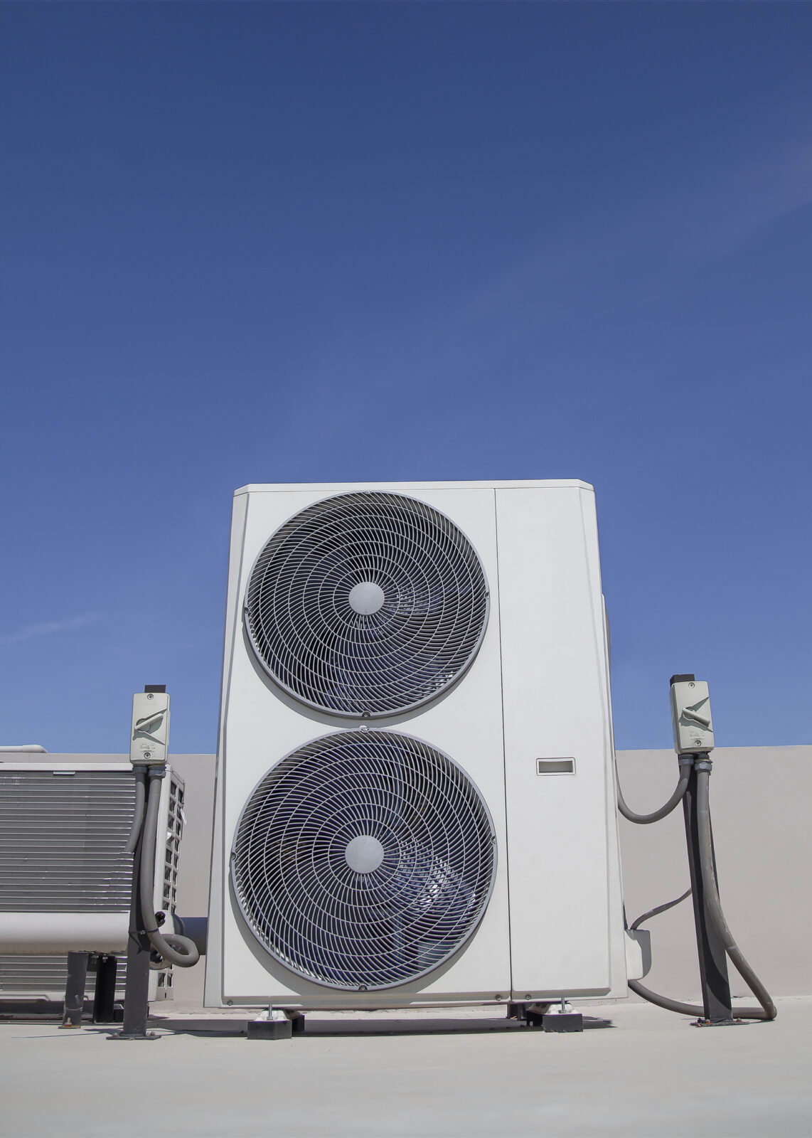 Air conditioning on the roof of an industrial building with blue sky and clouds in the background